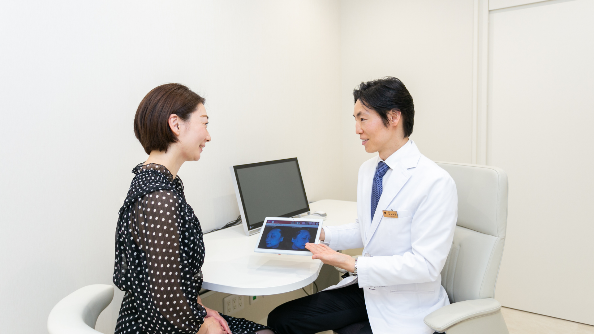 医師が患者に肌の状態を説明している診察風景