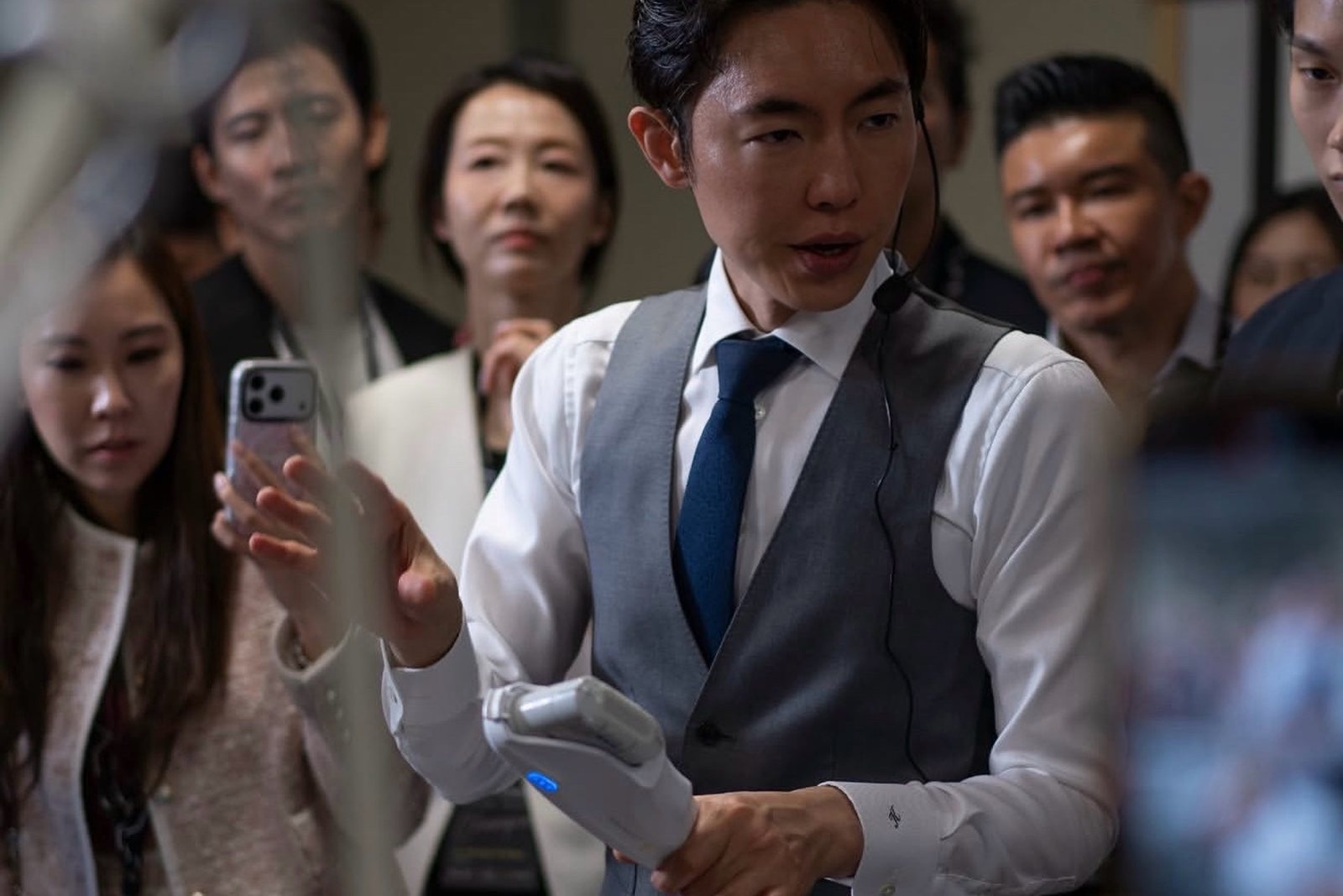 ハンドピースを手に、囲む参加医師たちへ説明する奥謙太郎院長