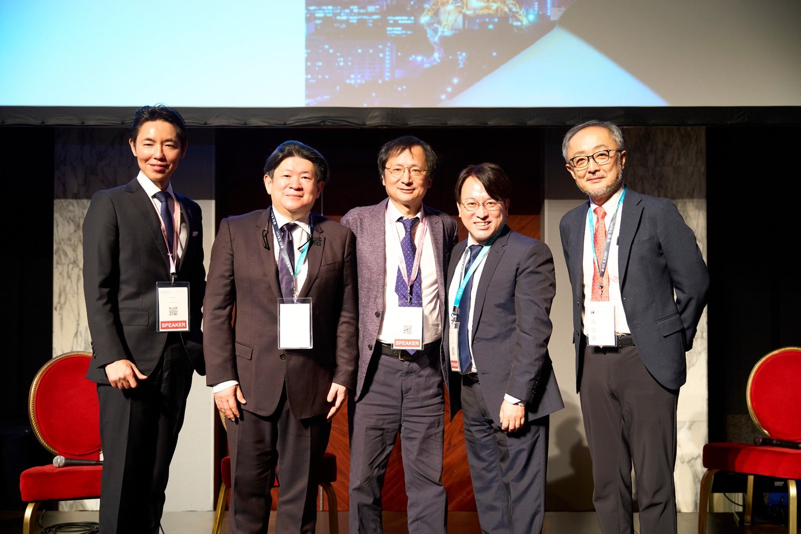 AMWC JAPAN 2026の色素治療のセッションの登壇者と並ぶヒルズグレイスクリニック院長 奥謙太郎(左端)